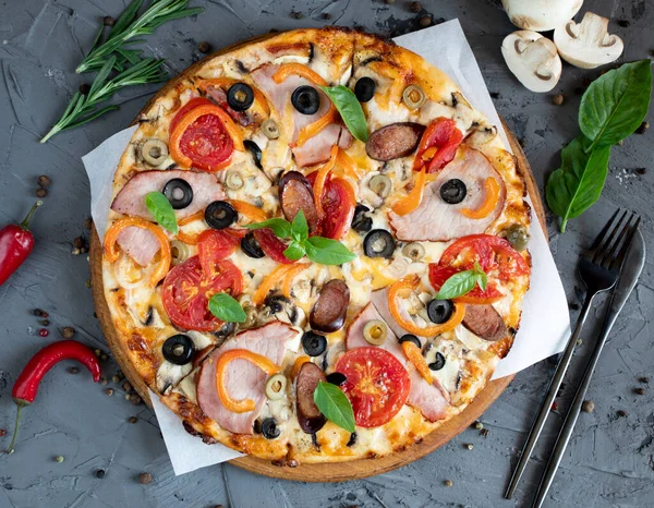 Göğüs eti, sosis, domates ve zeytinli pizza.