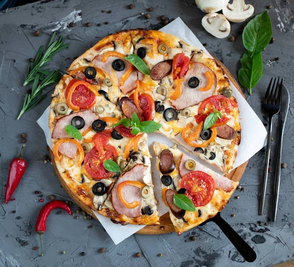 Göğüs eti, sosis, domates ve zeytinli pizza.