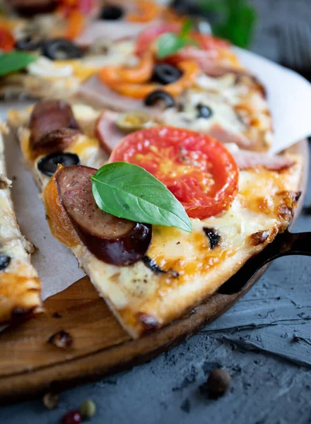 Göğüs eti, sosis, domates ve zeytinli pizza.