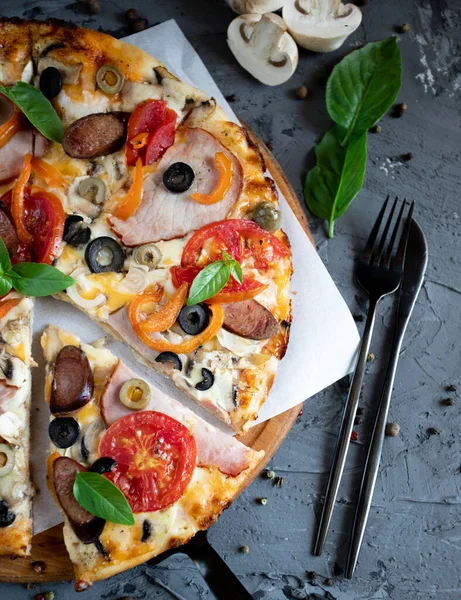 Göğüs eti, sosis, domates ve zeytinli pizza.