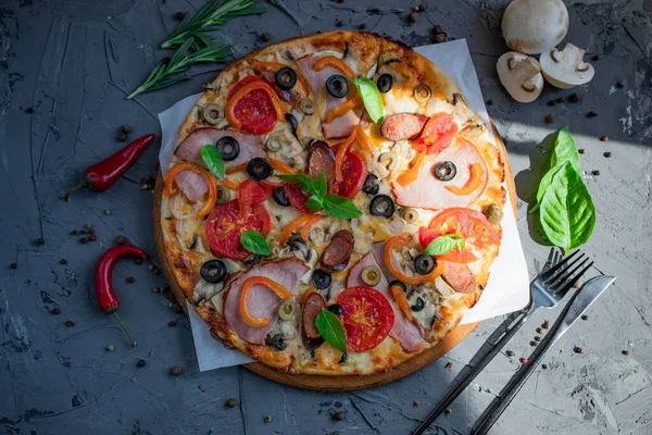 Göğüs eti, sosis, domates ve zeytinli pizza.