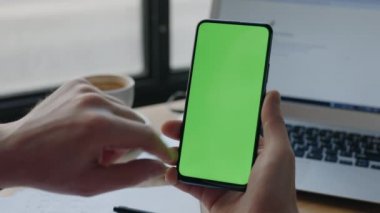 Cep telefonunda yazan adam dikey yeşil ekranda. Krom anahtar ve maket.