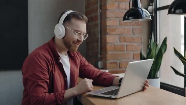 Videollamada. Guy está utilizando el ordenador portátil para la comunicación de vídeo en la cafetería moderna. — Vídeos de Stock