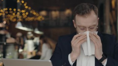 İşadamı laptopun başında otururken burnunu dokuya sümkürmüş..