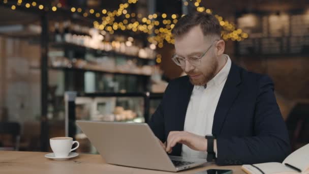 Muž pracující v kavárně a písař. Zaměstnanec odpovídá na e-maily. Obchodní koncept. — Stock video