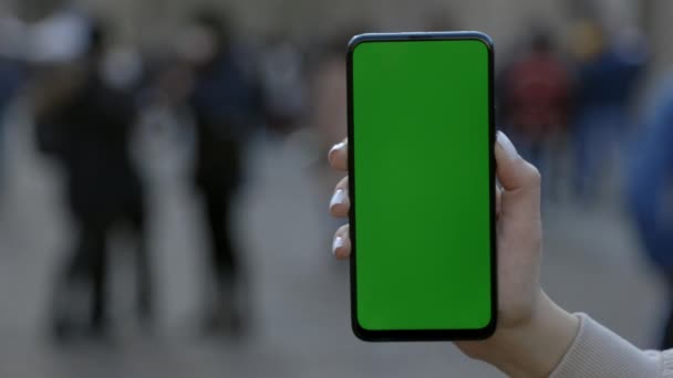 Vrouw op straat met behulp van smartphone met groene mock-up scherm chroma sleutel. — Stockvideo