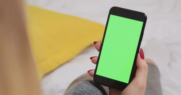 Vrouw op zoek naar het groene chroma sleutel scherm op smartphone-apparaat. — Stockvideo