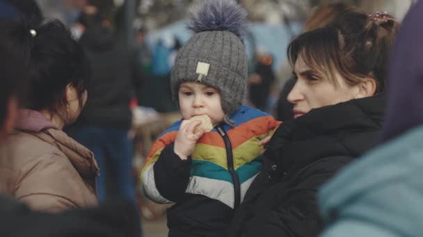 Lviv, Ukrayna - 15 Mart 2022: Lviv tren istasyonunda Avrupa 'ya kaçmak için bekleyen Ukraynalı anne ve oğul mülteciler. Bir kadın çocuğunu elinden tutuyor.. — Stok video