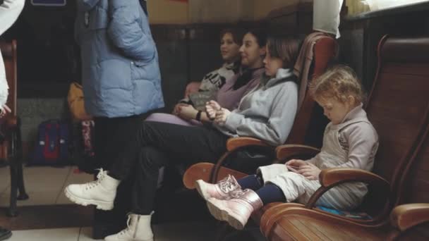 Lviv, Ucraina - 15 marzo 2022: La crisi umanitaria in Europa causata dall'attacco russo all'Ucraina. Rifugiati ucraini alla stazione ferroviaria. Piccola ragazza triste al primo piano. — Video Stock