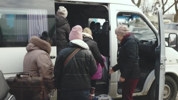 Lviv, Oekraïne - 15 maart 2022: Evacuatiebus voor vluchtelingen, begeleid door pro-Russische rebellen, die zich verplaatst tussen verschillende Oekraïense steden. Gedwongen migratie, mensen verlaten hun huis. — Stockvideo