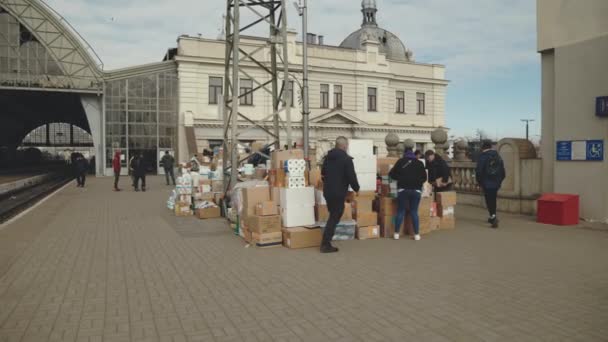 Lviv, Oekraïne - 15 maart 2022: Dozen met humanitaire hulp. Vluchtelingen uit Oekraïne op het treinstation met de hulp uit Europa. Oorlog met Rusland op Oekraïne concept. — Stockvideo
