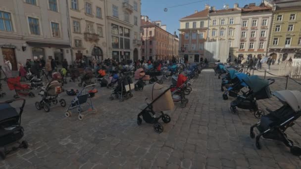 Lwów, Ukraina - 18 marca 2022: 109 puste wózki dziecięce na placu Rynok we Lwowie symbolizują ukraińskie dzieci zabite od początku wojny rosyjsko-ukraińskiej. — Wideo stockowe