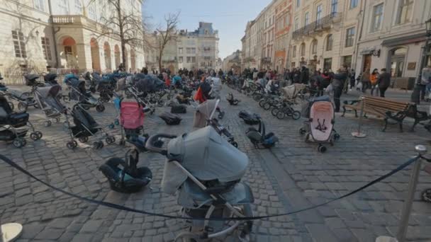 Lviv, Ukraine - 18 mars 2022 : 109 landaus vides sur la place Rynok à Lviv symbolisent des enfants ukrainiens tués depuis le début de la guerre russo-ukrainienne. — Video