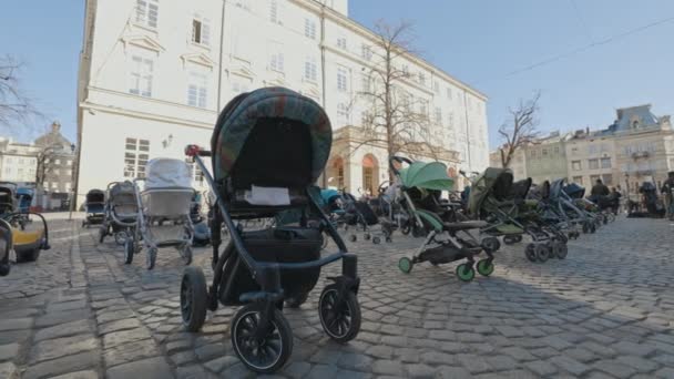 Lviv, Ucrânia - 18 de março de 2022: Prams vazios na Praça Rynok em Lviv simbolizam crianças ucranianas mortas desde o início da guerra Rússia-Ucrânia. — Vídeo de Stock
