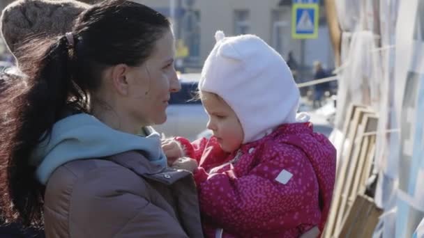 Lviv, Oekraïne - 15 maart 2022: Oekraïense moeder en dochter vluchtelingen staan op station Lviv te wachten op de trein naar Europa te ontsnappen. vrouw kalmerend haar kind door de handen. — Stockvideo