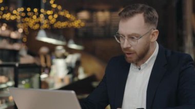 Kızgın işadamı kafede görüntülü sohbette tartışıyor. Saldırgan erkek yönetici uzak bir iş yerindeki dizüstü bilgisayardan video görüşmesi yapıyor. Duygusal Adam.