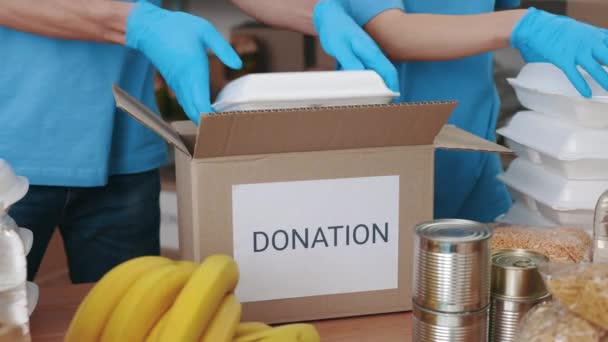 Close up of volunteers in gloves packing donation boxes — Stock Video
