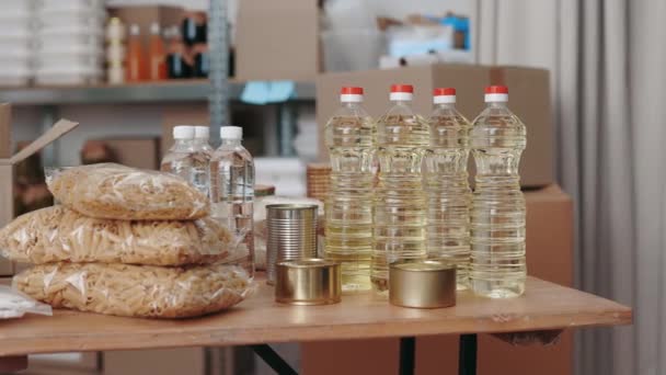 Botellas de agua, aceite, pasta y productos enlatados en el banco de alimentos — Vídeos de Stock