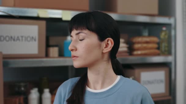 Portrait of female volunteer posing at food bank warehouse — Stock Video