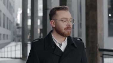 İş merkezinin yakınındaki sokakta kameraya gülümseyen işadamının portresi.