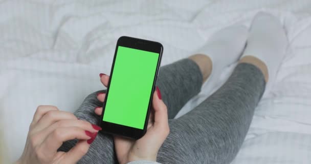 Zakenvrouw aan het bed met behulp van smartphone met groene mock up scherm, chroma sleutel. — Stockvideo
