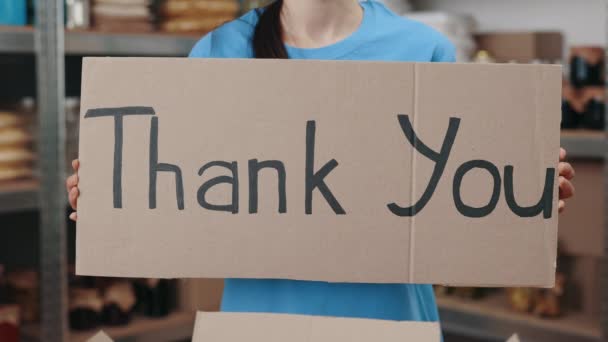 Female aid worker holding banner with phrase thank you — Stock Video