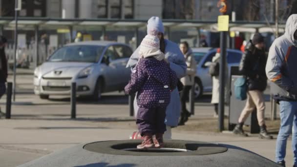 Leopoli, Ucraina - 15 marzo 2022: evacuati dall'Ucraina orientale vicino alla stazione ferroviaria nella città ucraina occidentale di Leopoli. Bambino che salta sul trampolino in strada. — Video Stock