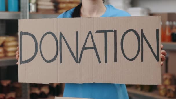 Mujer voluntaria sosteniendo en las manos pancarta con donación de texto — Vídeos de Stock