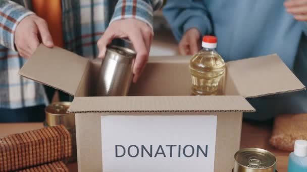 Caucasian volunteers filling donation boxes with food — Stock Video