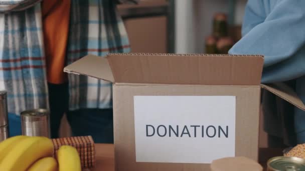 Vrijwilligers in handschoenen maken dozen klaar voor donatie — Stockvideo