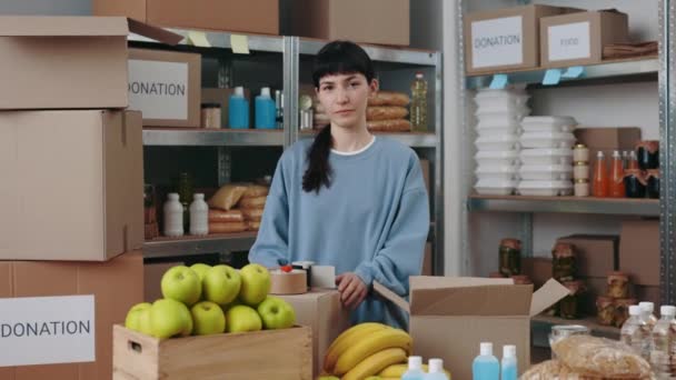 Lasdy uśmiecha się do kamery podczas pakowania żywności w funduszu charytatywnym — Wideo stockowe