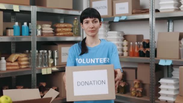 Female volunteer holding donation box at warehouse — Stock Video