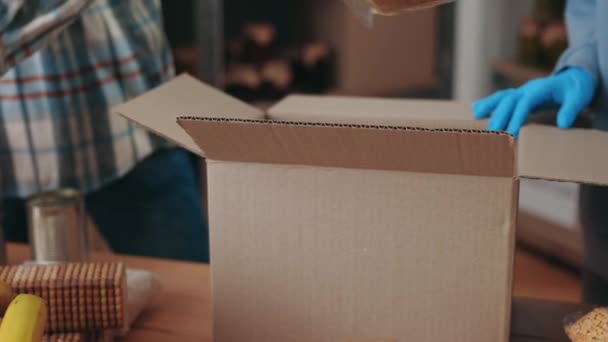 Trabajadores sociales en guantes preparando cajas de donaciones en el almacén — Vídeo de stock