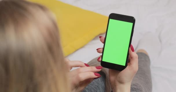 Frauenhand hält Mobiltelefon mit grünem Bildschirm und berührendem Display. — Stockvideo