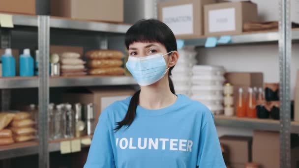 Mujer con máscara facial posando en el centro de donación de caridad — Vídeo de stock