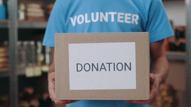 Крупним планом працівник продовольчого банку тримає подарункову коробку в руках — стокове відео