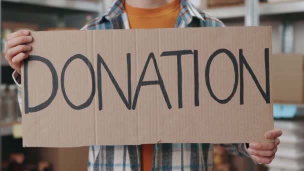 Close up of male volunteer holding banner with donation text — Stock Video