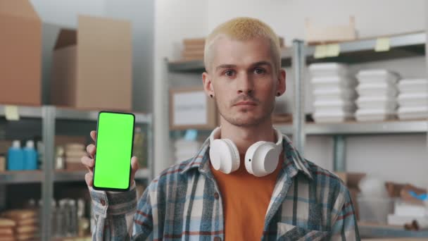 Чоловічий хіпстер тримає мобільний з зеленим екраном в продовольчому банку — стокове відео