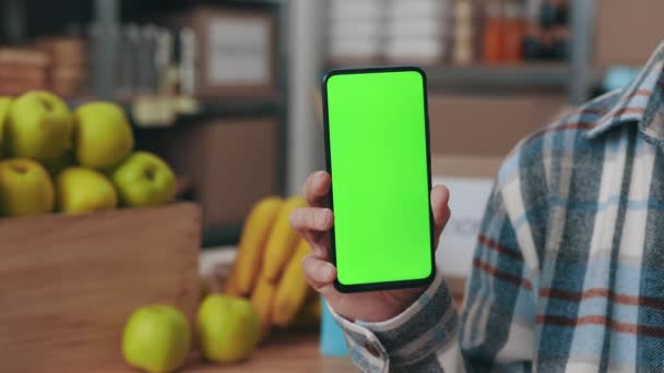 Voedselbank werknemer met smartphone met mock-up scherm — Stockvideo