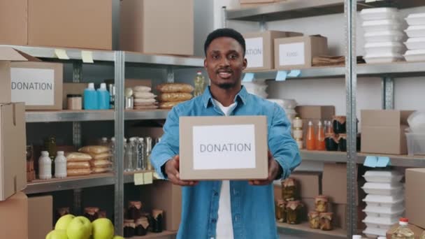 Afričan samec dobrovolník držení lepenky darovací box — Stock video