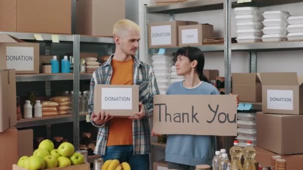 Freiwillige halten Spendenbox und Dankeschön-Banner in der Hand — Stockvideo