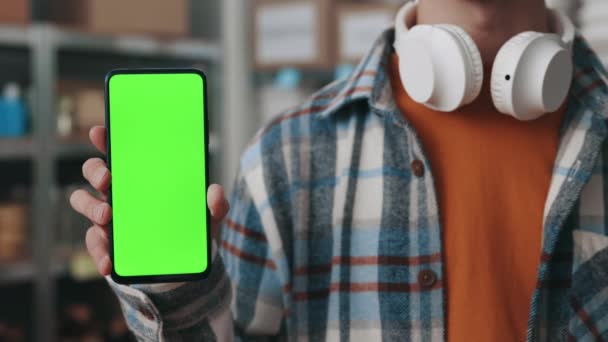 Крупный план мужчины-добровольца, держащего мобильный телефон с зеленым экраном — стоковое видео