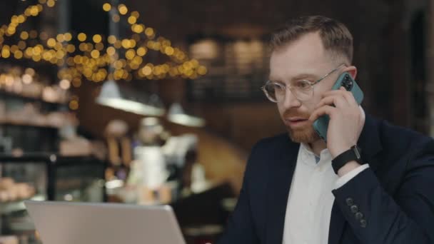 Επιχειρηματίας που εργάζεται στο καφέ, κάθεται με το laptop, μιλώντας με τον πελάτη. — Αρχείο Βίντεο