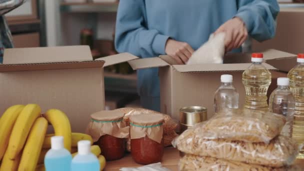 Primer plano de voluntarios que seleccionan alimentos para su donación en el almacén — Vídeos de Stock