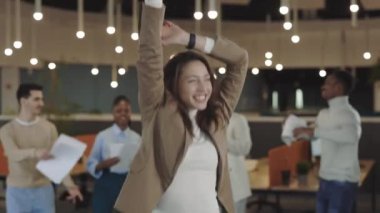 Modern ofiste dans eden mutlu genç iş kadını ve bir yığın belgeyi çöpe atıyor. Başarılı işçi şirket partisinde ve iş gezisinde başarıyı kutladı.