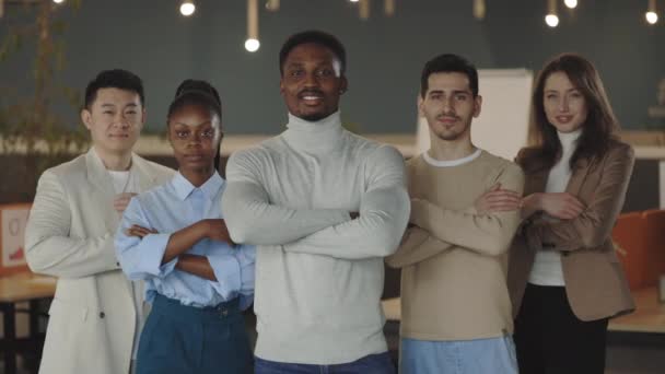 Portret van gelukkige zakenmensen die in de kantoorruimte staan en naar de camera kijken met gevouwen armen. Multi-etnische professionele medewerkers poseren samen voor corporate team portret, leiderschap. — Stockvideo