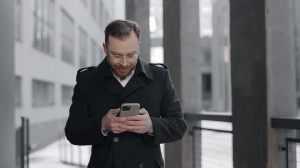 Biznesmen jest podekscytowany wiadomościami ze smartfona. Ludzie biznesu. — Wideo stockowe