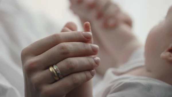 Annenin eli kapalıyken, yeni doğmuş tatlı bir bebekle oynarken.