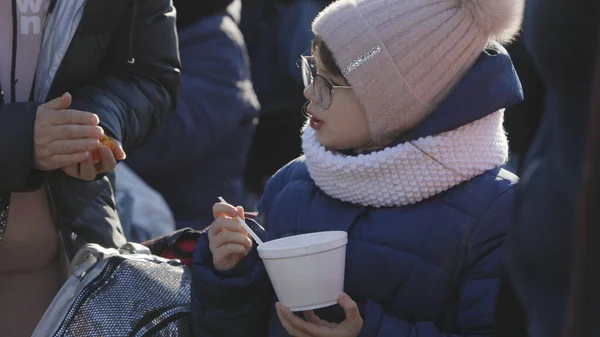 Lviv, Ukrayna - 15 Mart 2022: Çocuk Ukrayna 'dan tahliye sırasında sokaktaki tren istasyonunda yemek yiyor. Ukraynalı mülteciler. - Savaş. Rusya Ukrayna konseptine saldırdı.