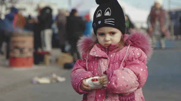 Lviv, Ukrayna - 15 Mart 2022 Sokakta duran küçük bir kızın portresi. Batı Ukrayna 'nın Lviv kentindeki tren istasyonu yakınlarındaki doğu Ukrayna' dan tahliye edilenler.